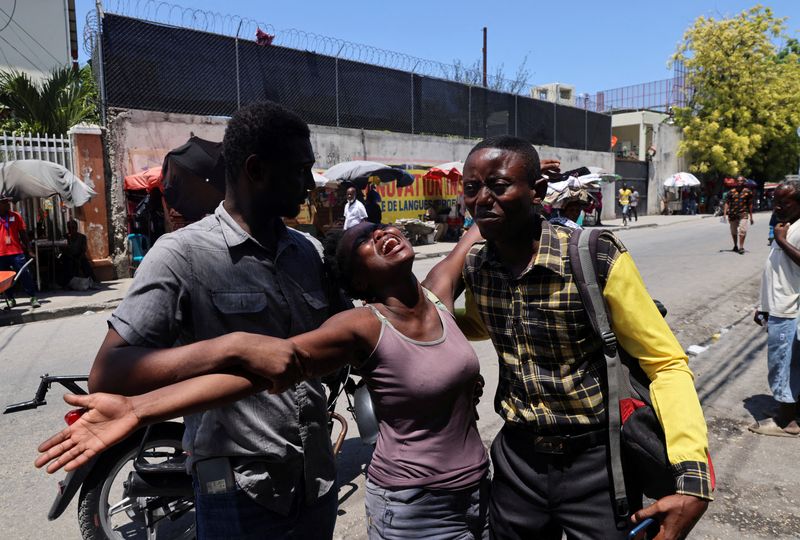 © Reuters. FILE PHOTO: A woman is helped by others as she reacts upon seeing the dead body of her brother who was shot dead by unknown assailants, in Port-au-Prince, Haiti September 9, 2024. REUTERS/Ralph Tedy Erol/File Photo