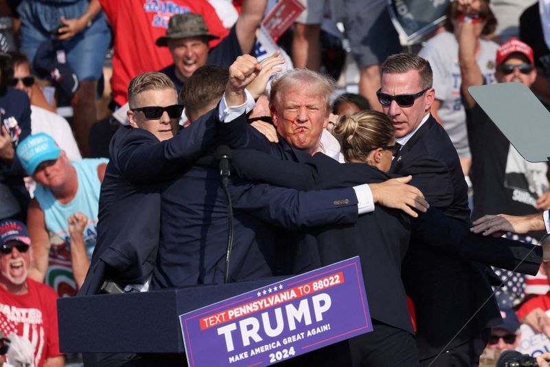 © Reuters. FILE PHOTO: Republican presidential candidate and former U.S. President Donald Trump gestures with a bloodied face as multiple shots rang out during a campaign rally at the Butler Farm Show in Butler, Pennsylvania, U.S., July 13, 2024. REUTERS/Brendan McDermid/File Photo