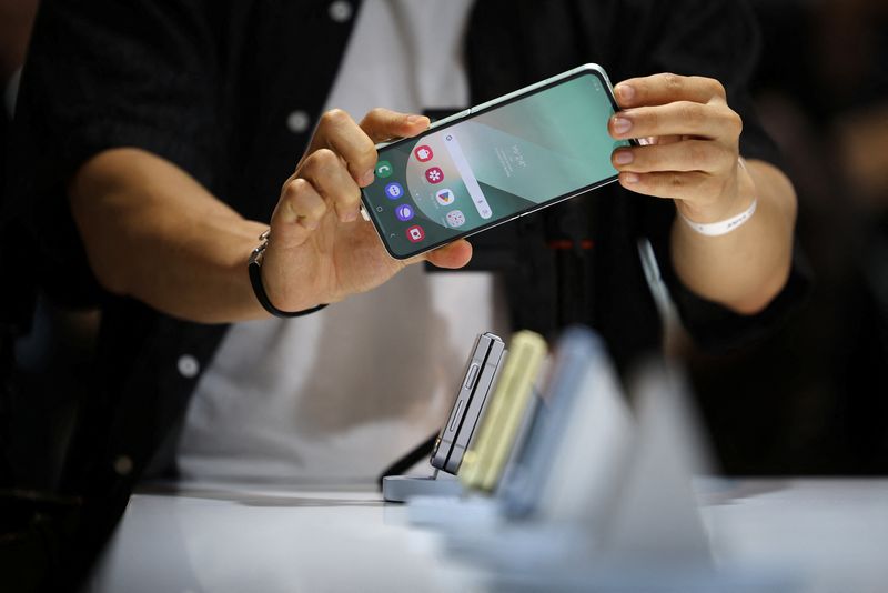 © Reuters. FILE PHOTO: An attendee tries out a Samsung Electronics' Galaxy Z Flip 6 during its unveiling ceremony in Seoul, South Korea, July 8, 2024.  REUTERS/Kim Hong-Ji/File photo