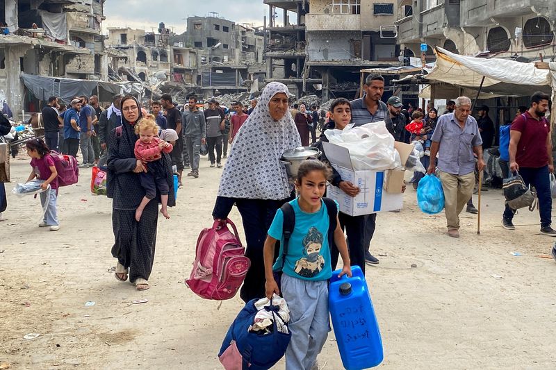 © Reuters. FILE PHOTO: Displaced Palestinians make their way as they flee areas in northern Gaza Strip following an Israeli evacuation order, amid the Israel-Hamas conflict, in Jabalia, October 6, 2024. REUTERS/Hussam Al-Zaanin/File photo