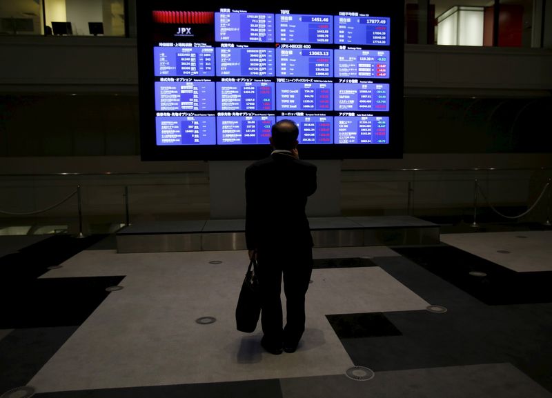 © Reuters. FILE PHOTO: A man looks at an electronic board showing Japan's Nikkei average and related indices at the Tokyo Stock Exchange (TSE) in Tokyo August 26, 2015. REUTERS/Yuya Shino/File Photo