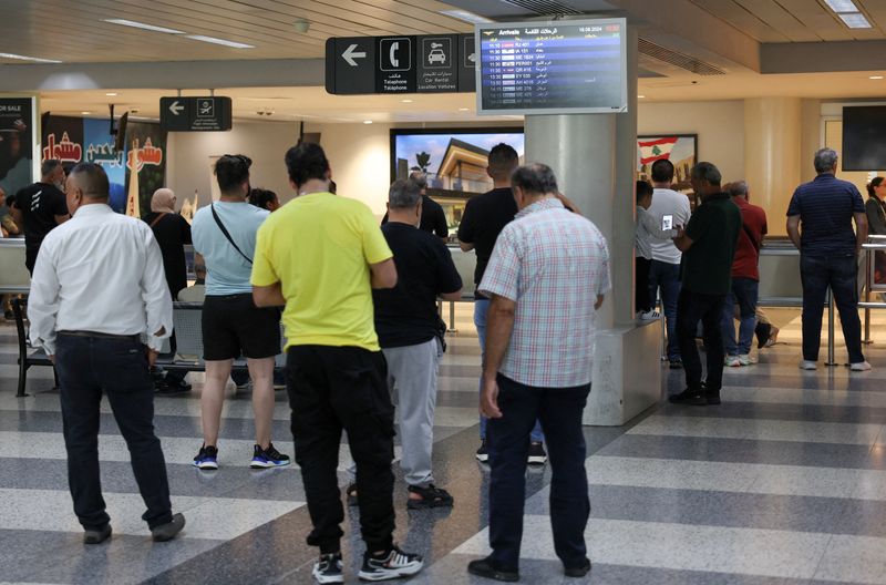 © Reuters. FILE PHOTO: People stand at Beirut-Rafic Hariri International Airport, a day after hand-held radios used by armed group Hezbollah detonated across Lebanon's south, in Beirut, Lebanon September 19, 2024. REUTERS/Mohamed Azakir/File Photo