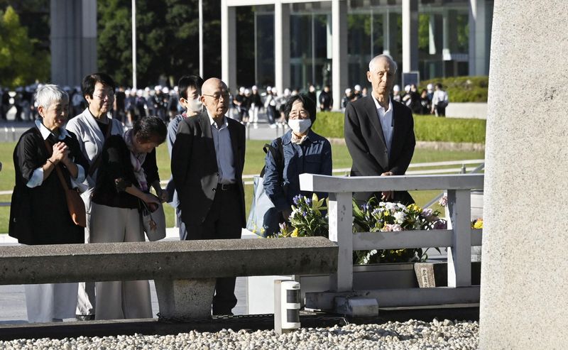 © Reuters. FILE PHOTO: An atomic bomb survivor Kunihiko Sakuma (C) visits the Cenotaph for the Victims of the Atomic Bomb at the Hiroshima Peace Memorial Park, on the following day of The Japan Confederation of A- and H-Bomb Sufferers Organizations (Nihon Hidankyo) winning the 2024 Nobel Peace Prize, in Hiroshima, Japan, October 12, 2024, in this photo taken by Kyodo. Mandatory credit Kyodo/via REUTERS/File Photo