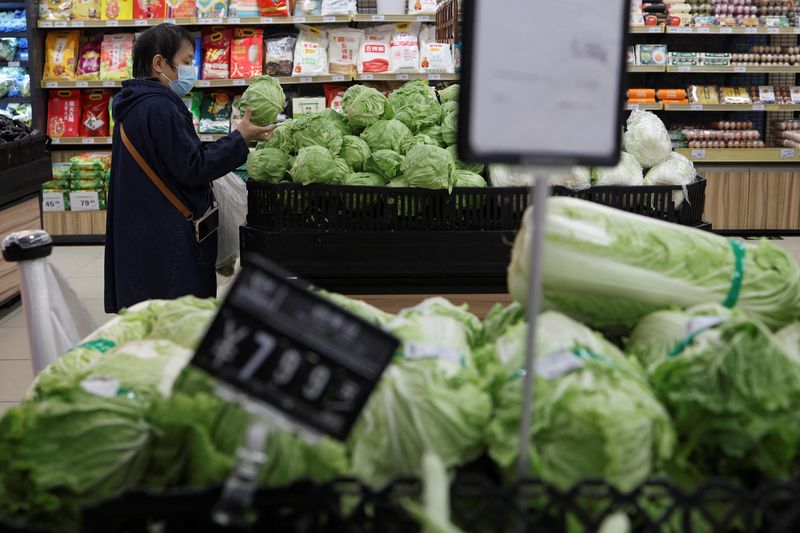 © Reuters. FILE PHOTO: A customer shops for cabbages at the vegetable section of a supermarket in Beijing, China October 17, 2024. REUTERS/Florence Lo/File Photo