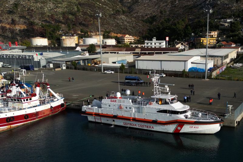 © Reuters. A drone view shows an Italian coast guard vessel preparing to depart for Italy with migrants, who were intercepted at sea and later detained at a reception facility in Albania, after a court in Rome overturned their detention orders, in Shengjin, Albania, October 19, 2024. REUTERS/Florion Goga