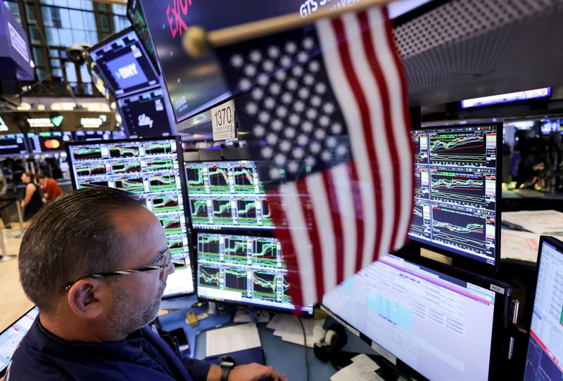 © Reuters. A trader works at the New York Stock Exchange (NYSE) next to a U.S. flag, after Republican Donald Trump won the U.S. presidential election, in New York City, U.S., November 6, 2024. REUTERS/Andrew Kelly/File Photo