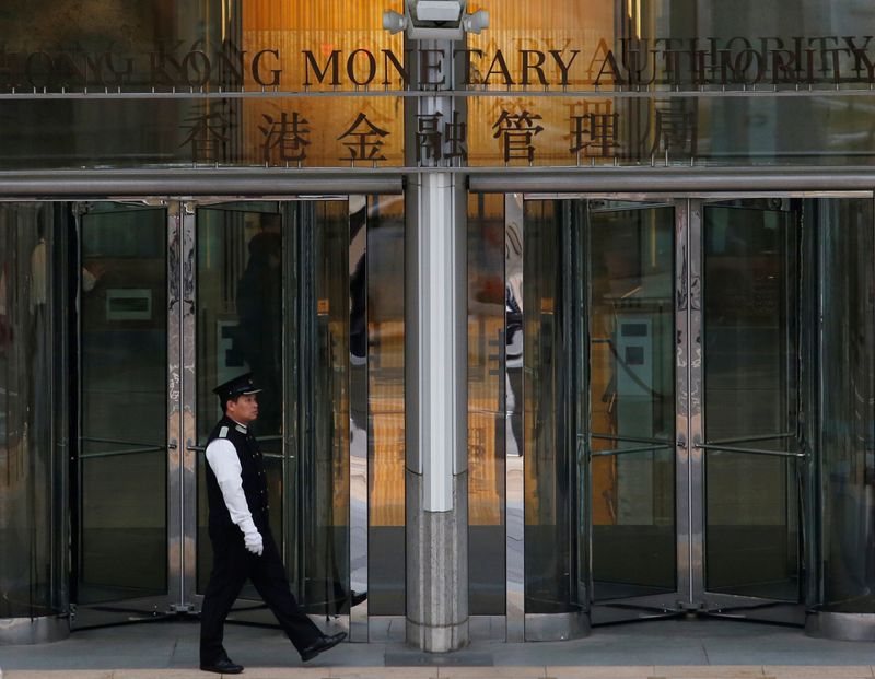 © Reuters. FILE PHOTO: An attendant walks outside the entrance to Hong Kong Monetary Authority in Hong Kong, China November 10, 2015. REUTERS/Bobby Yip/File Photo