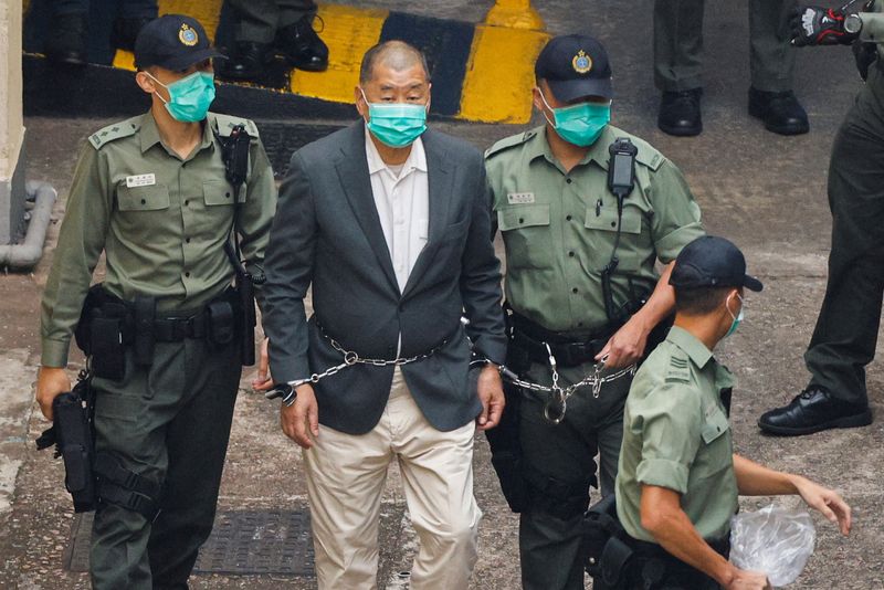 © Reuters. FILE PHOTO:Media mogul Jimmy Lai Chee-ying, founder of Apple Daily, walks to a prison van to head to court, after being charged under the national security law, in Hong Kong, China December 12, 2020. REUTERS/Tyrone Siu/File Photo