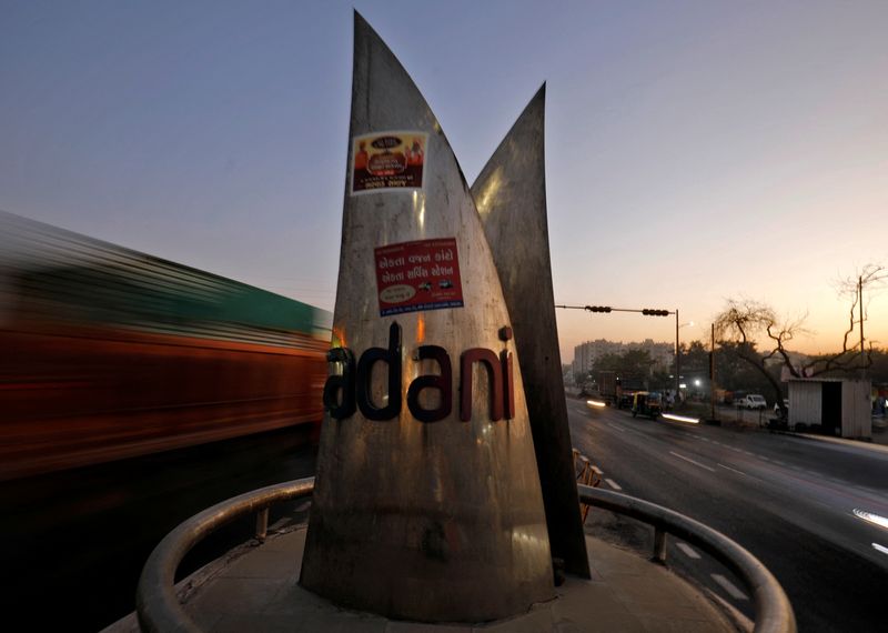 © Reuters. FILE PHOTO: Traffic moves past the logo of the Adani Group installed at a roundabout on the ring road in Ahmedabad, India, February 2, 2023. REUTERS/Amit Dave/File Photo